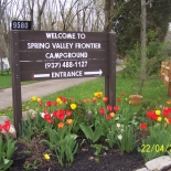 Campground sign with red and yellow flowers